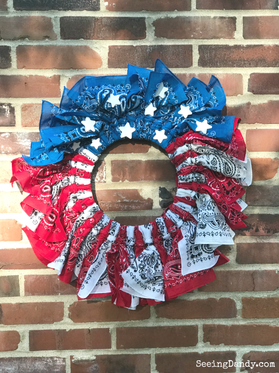 farmhouse style wreath, red, white and blue 4th of July wreath hanging on a brick wall.