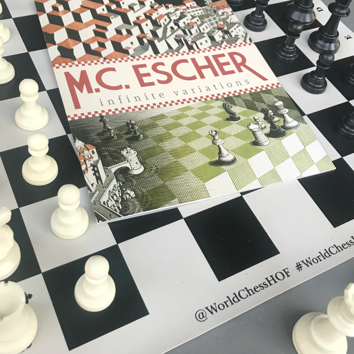 MC Escher Infinite Variations exhibit pamphlet on chess board.