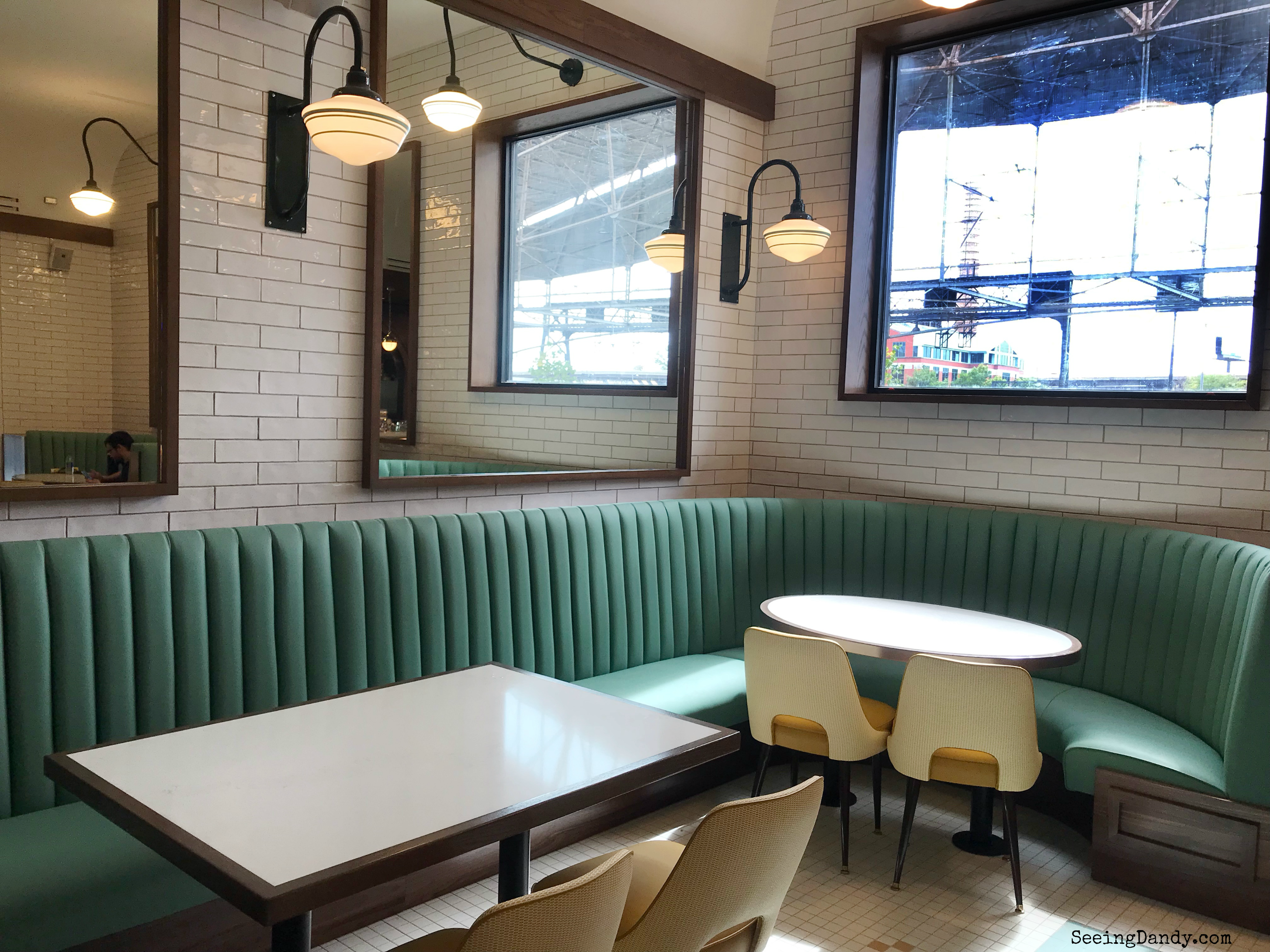 Vintage eating area with mint green booths and retro white subway tile.