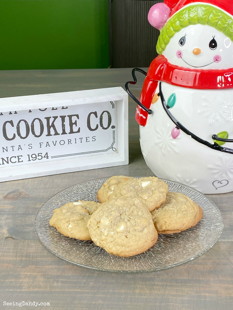 Cookies on farmhouse table with Precious Moments snowman cookie jar and Santa's cookie company sign.