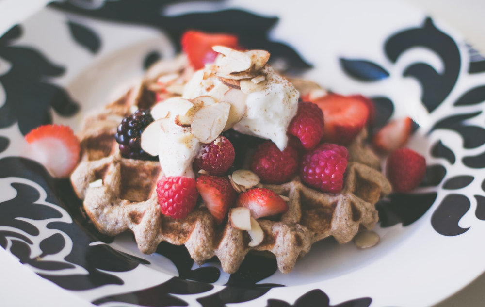 Delicious Belgian waffles covered in fresh fruit, strawberries blackberries raspberries, whipped cream, sliced almonds, black and white damask plate, national waffle day, waffle recipes, delicious recipes, foodie, breakfast recipes 