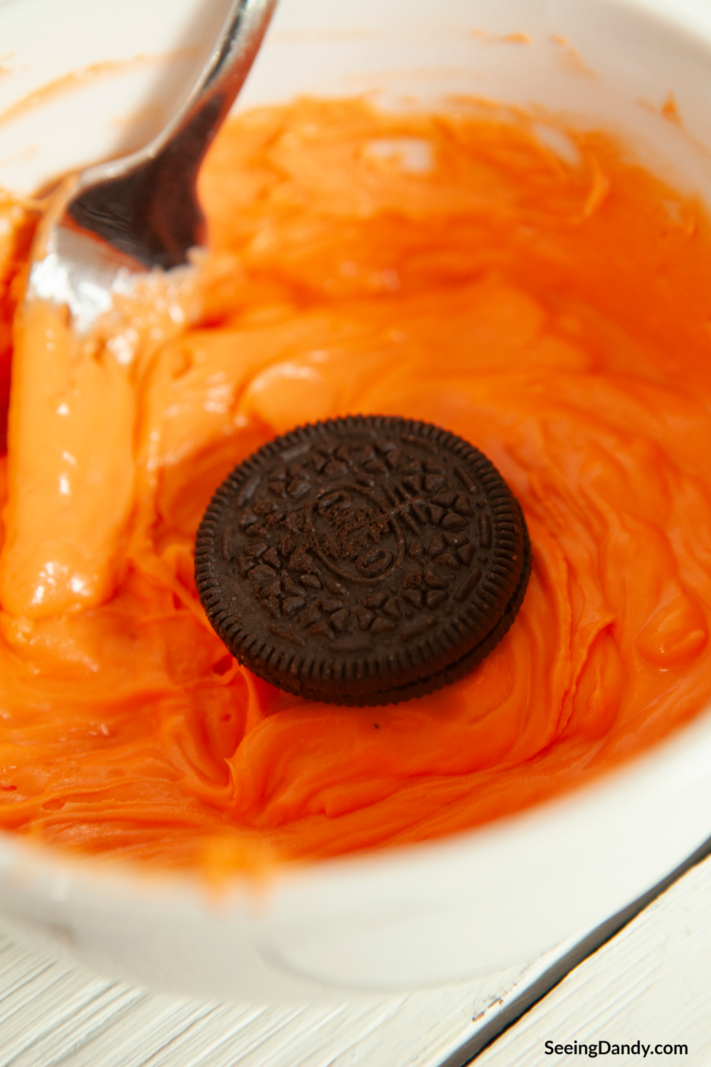 dipping oreo cookie in orange chocolate