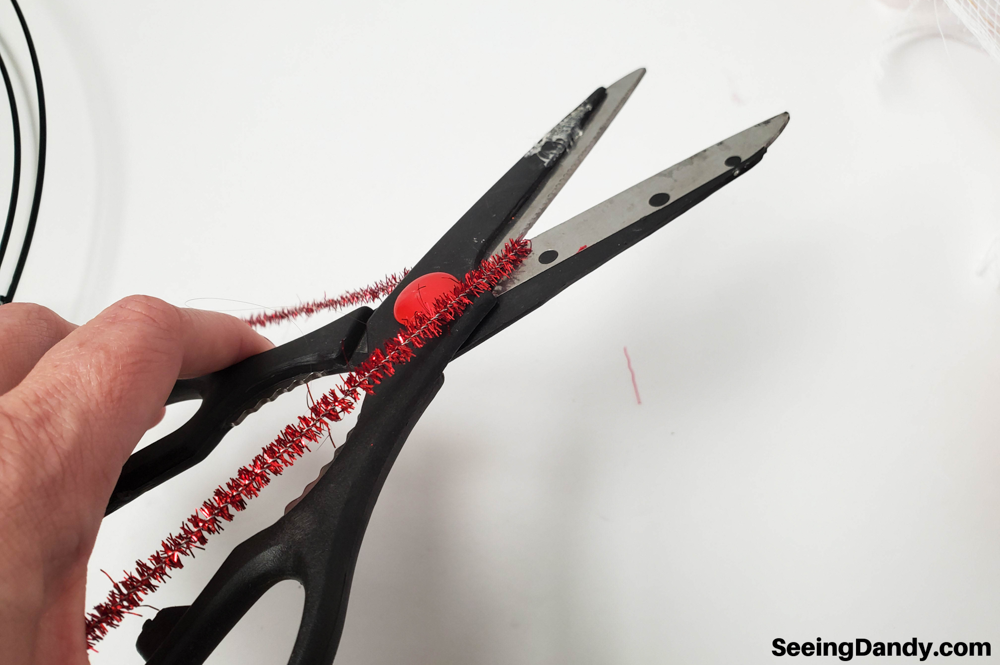 cutting red sparkle pipe cleaner