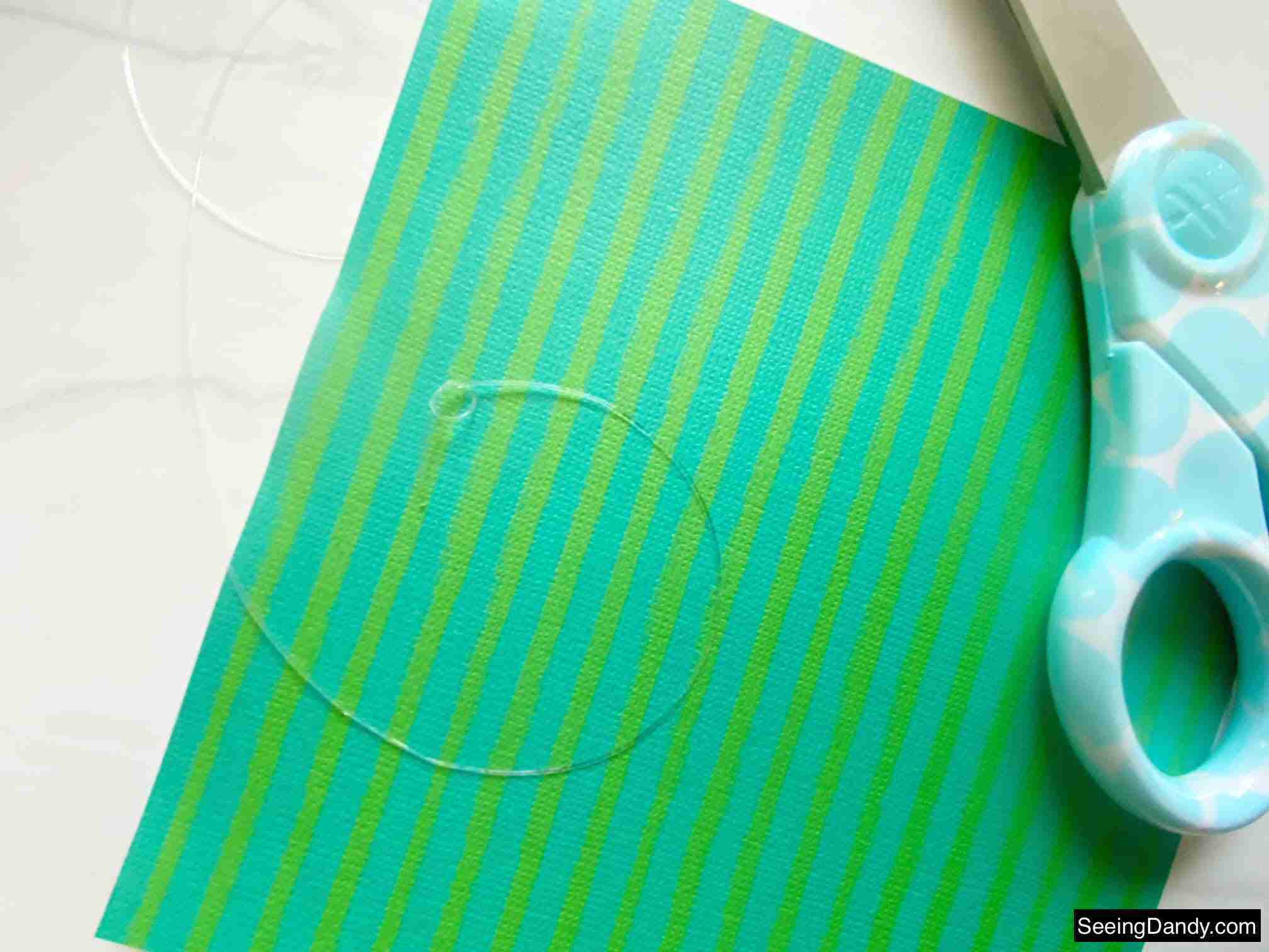 green blue stripe scrapbook paper, marble countertop, elasticity stretch bead cord, craft scissors, easy crafts, clear bracelet making elastic cord