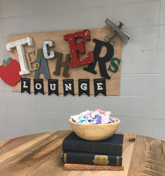 DIY teacher's lounge makeover sign and Rustic Grain barn wood table. Salt water taffy sitting on top of antique books.