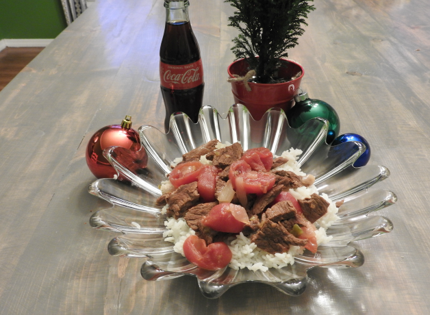 Instant Pot round steak served on glass plate. Farmhouse table with ornaments and miniature Christmas tree.