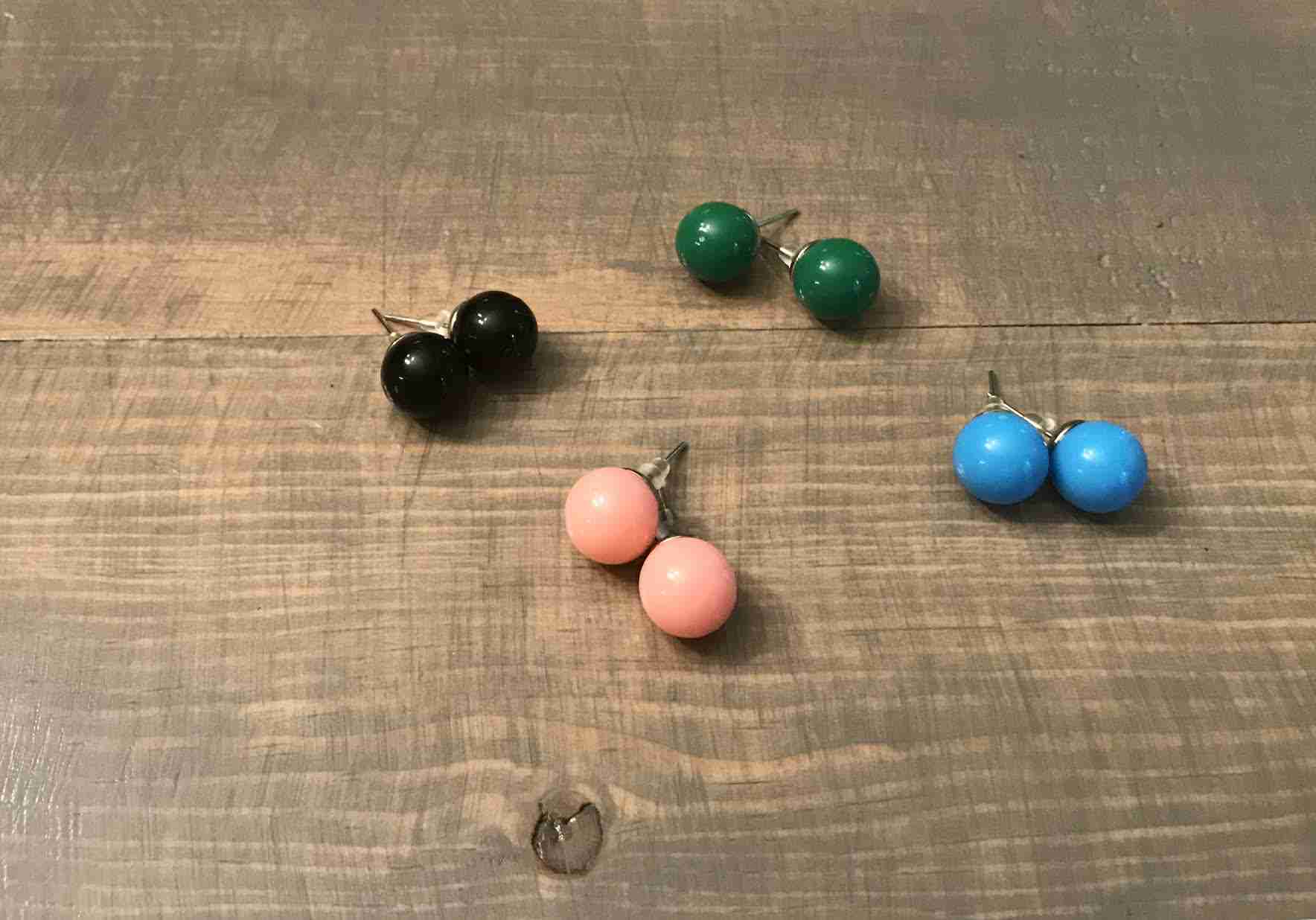 Gumball earrings on gray farmhouse table.