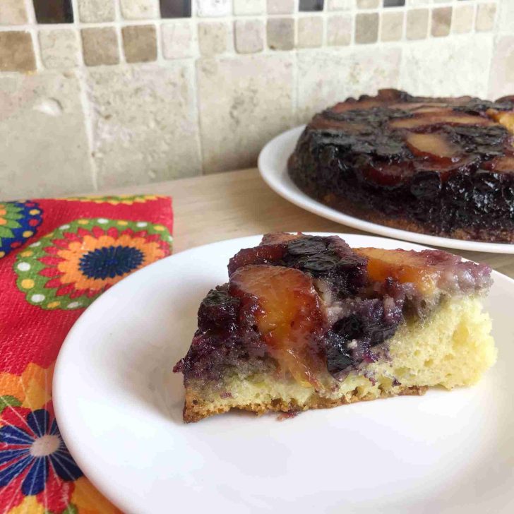 Peach blueberry upside down cake recipe with floral hand towel.