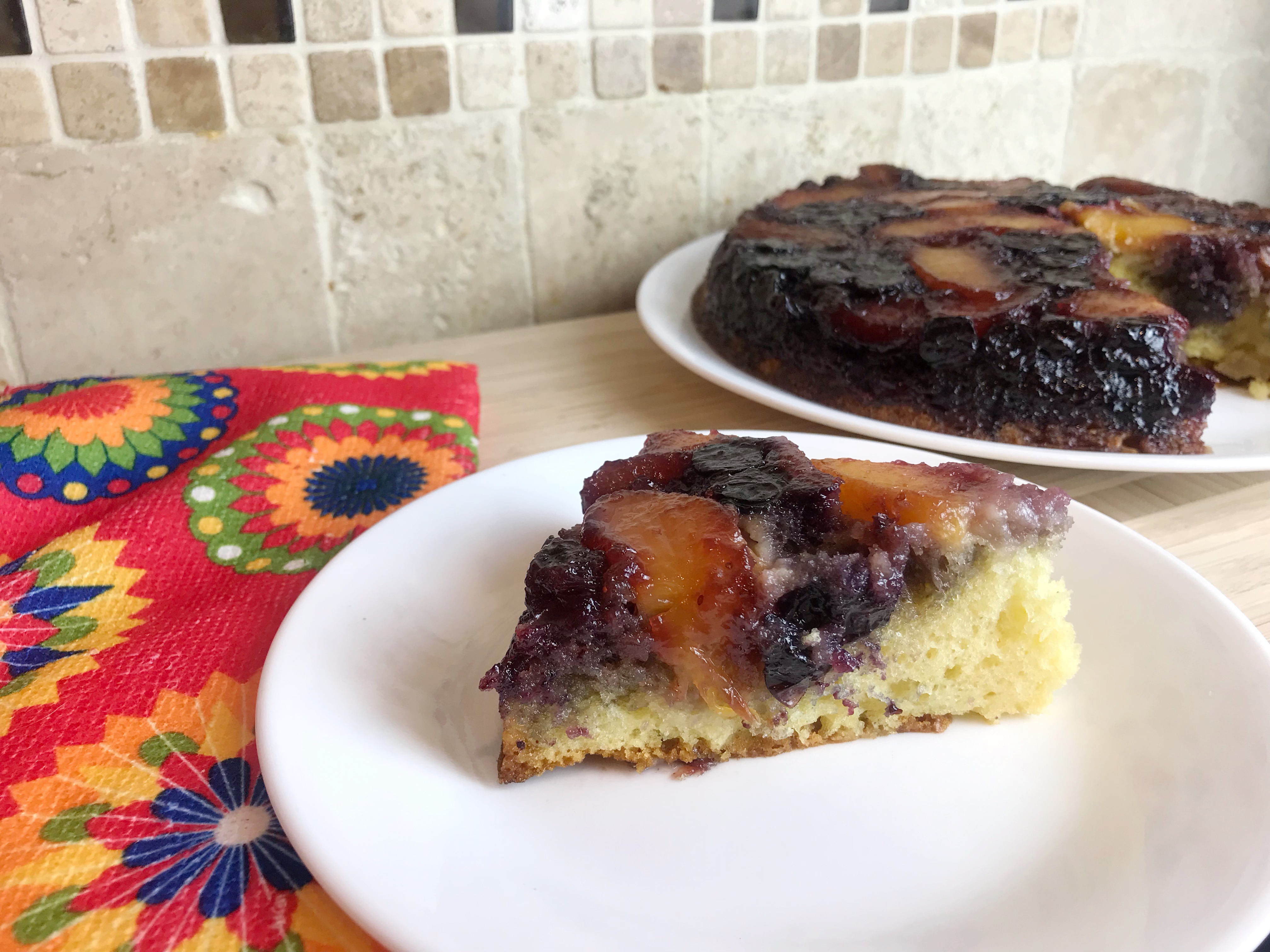 Peach blueberry upside down cake recipe with floral hand towel.